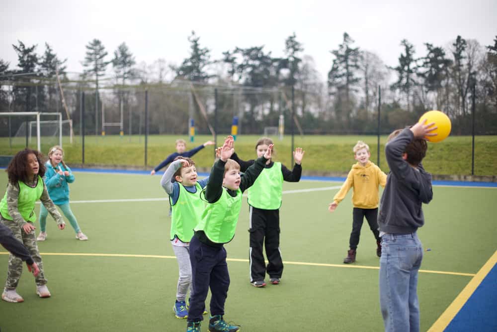 Children having fun at Educamps February Half Term Camp. They're playing handball with a group of new friends,